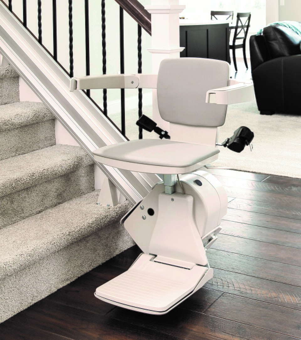 Bruno Elan straight stairlift with a folding seat alongside an indoor staircase